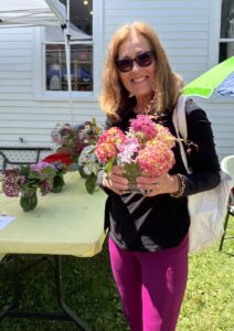 Happy customer at the Farmers' Market taking a beautiful arrangement home.